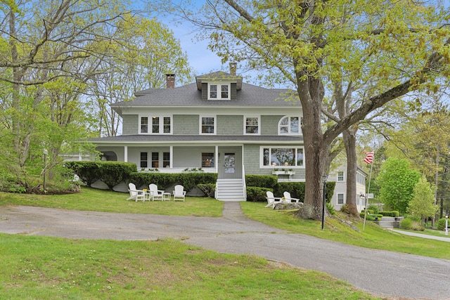 14 Oak St, Kennebunk, ME 04043 - view of front of house featuring a chimney, a front yard, roof with shingles, and covered porch
