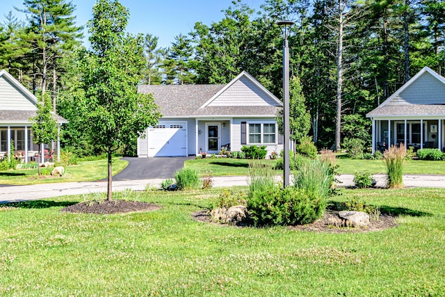 6 D St, Bridgton, ME 04009 - view of front of house featuring an attached garage, asphalt driveway, a front yard, and a shingled roof
