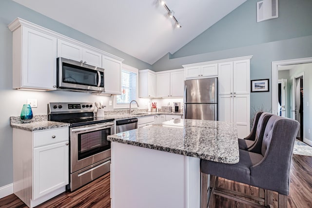 6 D St, Bridgton, ME 04009 - kitchen with appliances with stainless steel finishes, a sink, a center island, white cabinets, and dark wood-type flooring