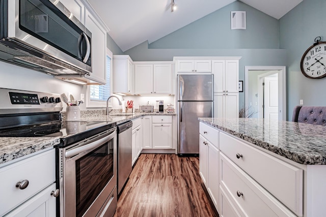 6 D St, Bridgton, ME 04009 - kitchen featuring appliances with stainless steel finishes, a sink, lofted ceiling, white cabinets, and light stone countertops