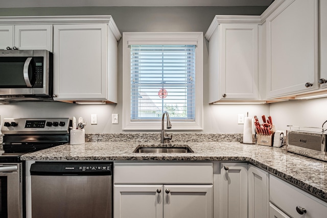 6 D St, Bridgton, ME 04009 - kitchen with appliances with stainless steel finishes, a sink, white cabinets, and light stone countertops