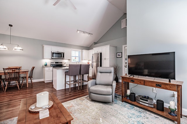 6 D St, Bridgton, ME 04009 - living area featuring dark wood finished floors, a ceiling fan, baseboards, and high vaulted ceiling