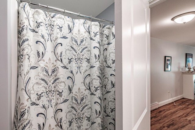6 D St, Bridgton, ME 04009 - full bathroom with wood finished floors, baseboards, and a shower with shower curtain