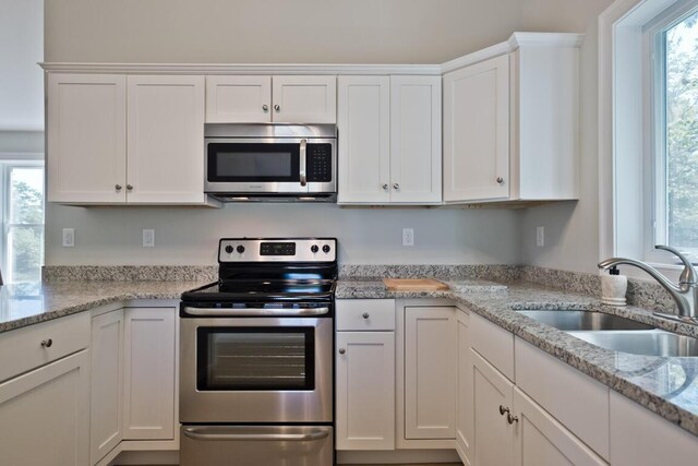 6 D St, Bridgton, ME 04009 - kitchen with appliances with stainless steel finishes, a sink, white cabinets, and light stone countertops