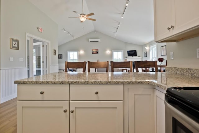 6 D St, Bridgton, ME 04009 - kitchen featuring rail lighting, lofted ceiling, ceiling fan, a wall mounted AC, and light wood-type flooring