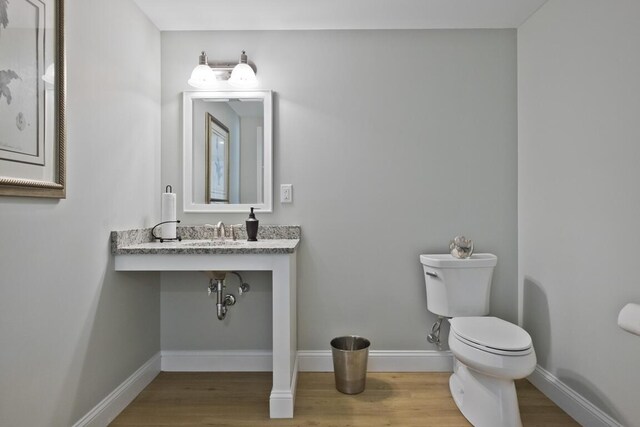 6 D St, Bridgton, ME 04009 - bathroom featuring toilet, wood finished floors, baseboards, and a sink