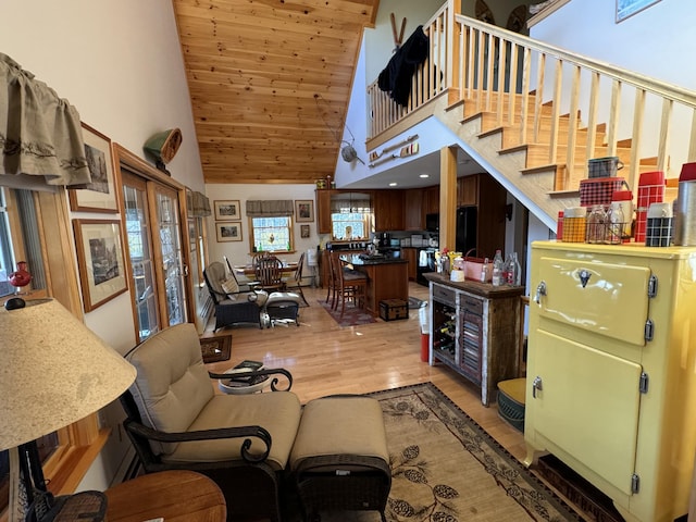 living room featuring high vaulted ceiling and light wood-style floors