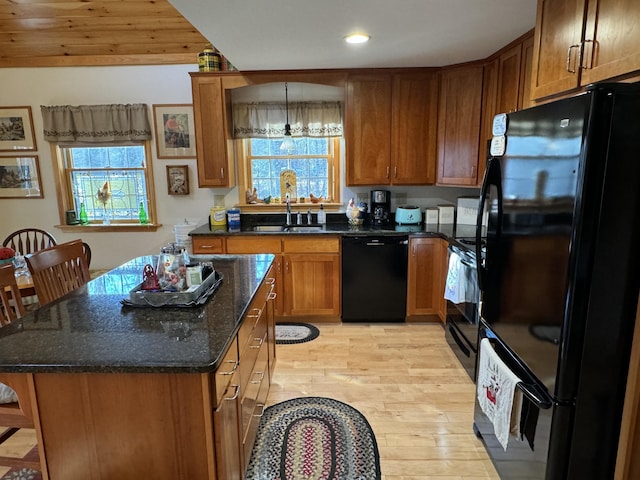 kitchen featuring black appliances, brown cabinetry, a sink, light wood-style floors, and recessed lighting