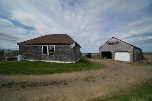899 Golden Ridge Rd, Sherman, ME 04476 - view of home's exterior with dirt driveway, an outdoor structure, and a garage