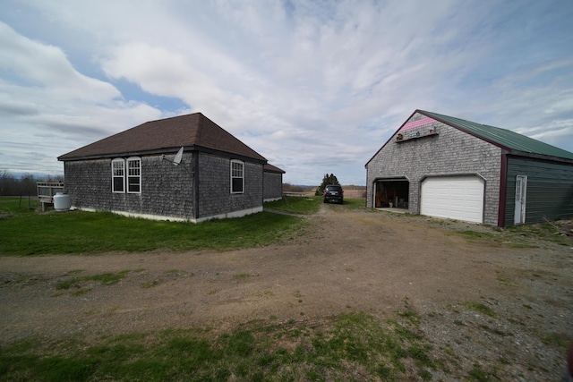 899 Golden Ridge Rd, Sherman, ME 04476 - view of property exterior featuring a detached garage, driveway, and an outdoor structure
