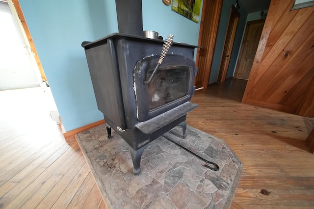 899 Golden Ridge Rd, Sherman, ME 04476 - detailed view of a wood stove, wood finished floors, baseboards, and a barn door