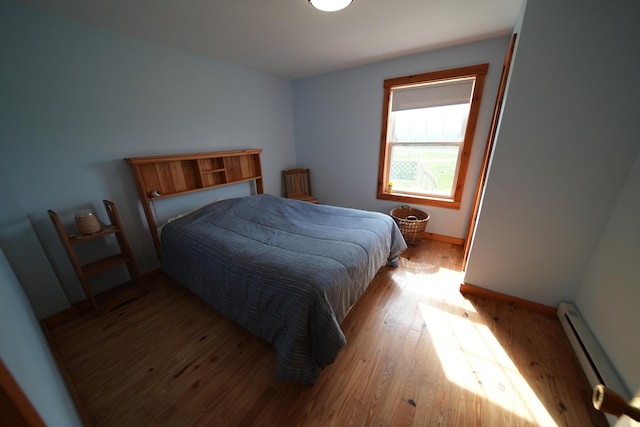899 Golden Ridge Rd, Sherman, ME 04476 - bedroom with baseboard heating and wood finished floors