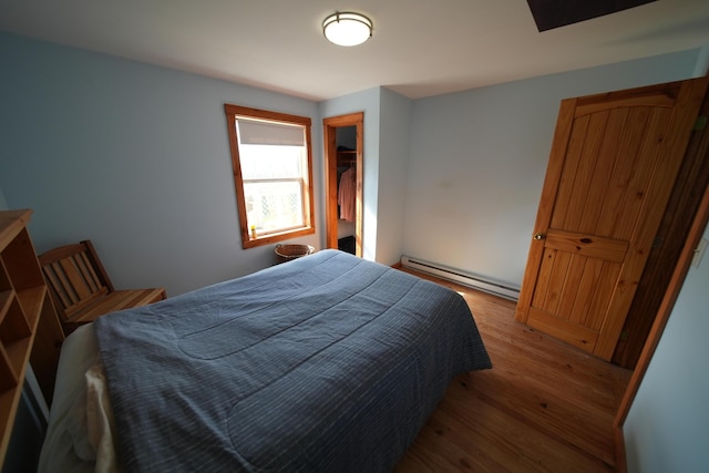 899 Golden Ridge Rd, Sherman, ME 04476 - bedroom with baseboard heating and wood finished floors