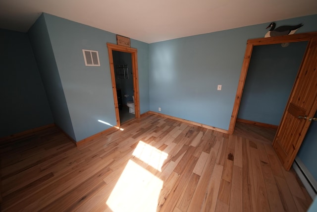 899 Golden Ridge Rd, Sherman, ME 04476 - unfurnished bedroom with light wood-style flooring, a baseboard heating unit, and baseboards