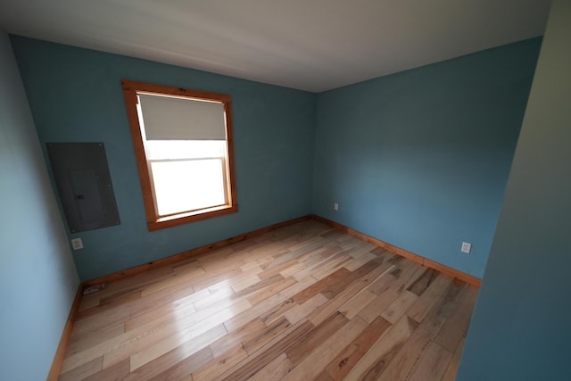 899 Golden Ridge Rd, Sherman, ME 04476 - unfurnished room featuring electric panel, light wood-style floors, and baseboards