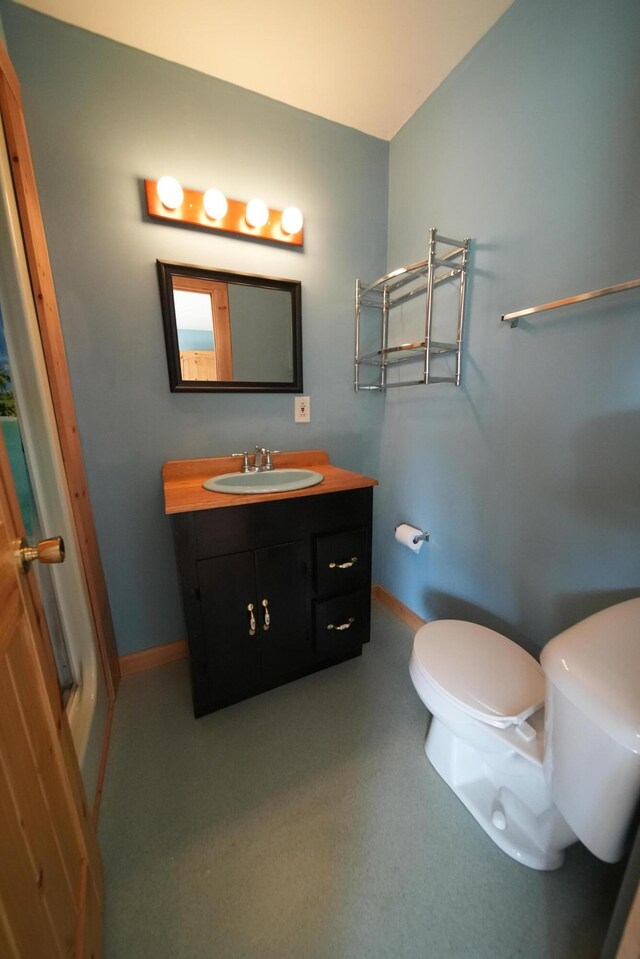 899 Golden Ridge Rd, Sherman, ME 04476 - bathroom with toilet, baseboards, and vanity