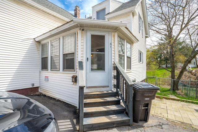 31 King St, Waterville, ME 04901 - doorway to property featuring fence, a shingled roof, and a chimney