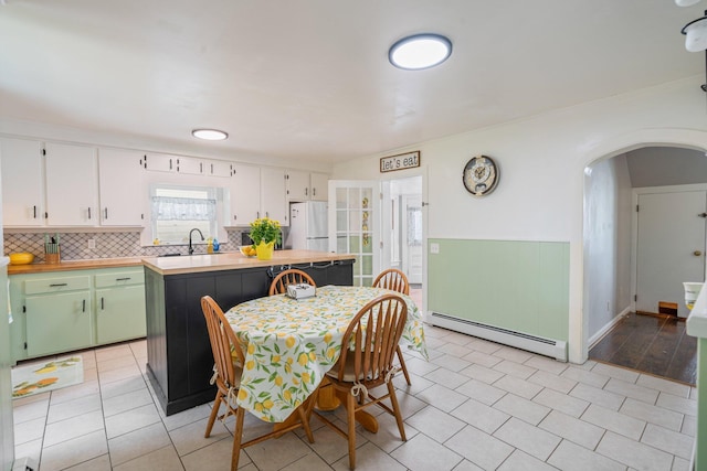 31 King St, Waterville, ME 04901 - dining area with a baseboard radiator, arched walkways, and light tile patterned floors