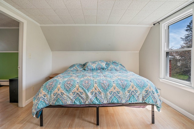 31 King St, Waterville, ME 04901 - bedroom with crown molding, wood finished floors, baseboards, vaulted ceiling, and a baseboard heating unit