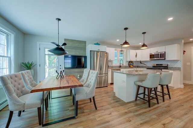 26 John Adams Ct, Naples, ME 04055 - kitchen with appliances with stainless steel finishes, a kitchen island, backsplash, plenty of natural light, and recessed lighting