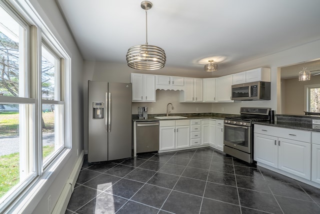 46 Silver Rdg, Veazie, ME 04401 - kitchen featuring stainless steel appliances, a sink, dark countertops, white cabinets, and pendant lighting