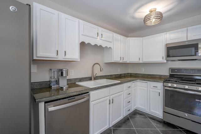 46 Silver Rdg, Veazie, ME 04401 - kitchen featuring appliances with stainless steel finishes, a sink, dark tile patterned flooring, white cabinets, and dark countertops