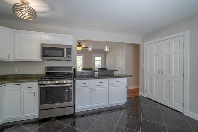 46 Silver Rdg, Veazie, ME 04401 - kitchen with stainless steel appliances, dark countertops, white cabinetry, and a peninsula