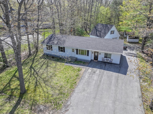 46 Silver Rdg, Veazie, ME 04401 - view of front of home featuring asphalt driveway, a shingled roof, a front yard, and a wooded view