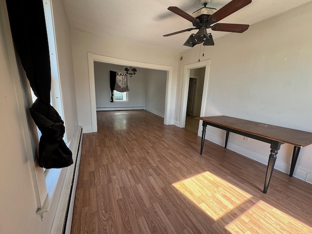932 Lisbon St, Lewiston, ME 04240 - empty room featuring a baseboard heating unit, wood finished floors, ceiling fan, baseboards, and a textured ceiling
