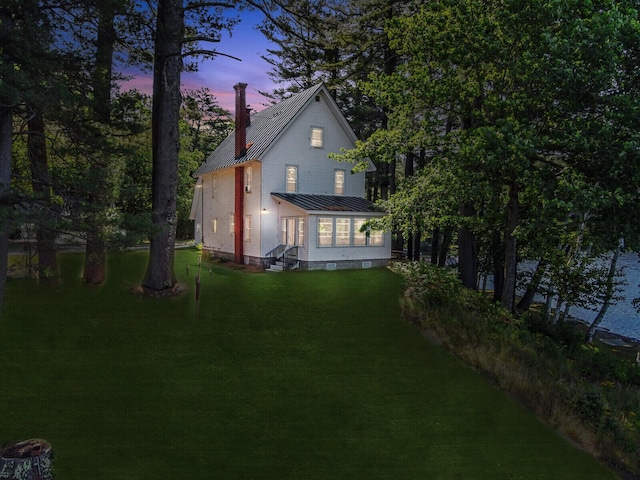 112 Buker Rd, Litchfield, ME 04350 - back of property featuring entry steps, a chimney, metal roof, a lawn, and a standing seam roof