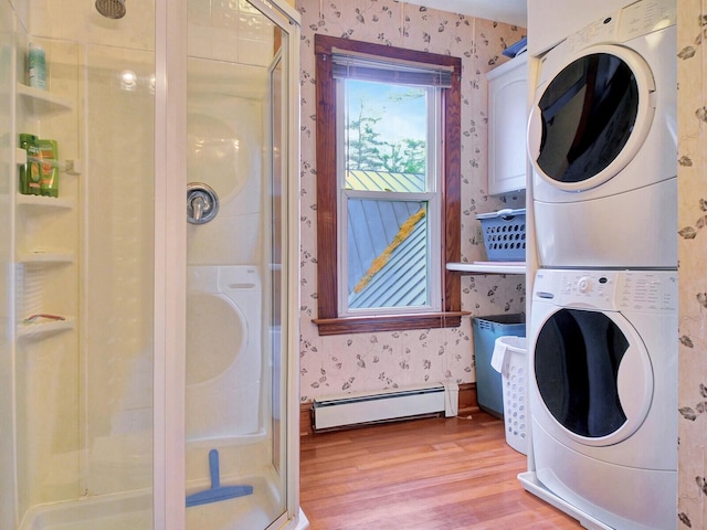 112 Buker Rd, Litchfield, ME 04350 - laundry area with baseboard heating, wallpapered walls, stacked washer and clothes dryer, and wood finished floors
