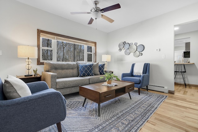 16 Gin Mill Ln, Windham, ME 04062 - living room featuring a baseboard heating unit, light wood-style floors, a ceiling fan, and baseboards