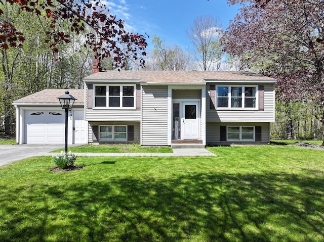 141 Cushman Rd, Winslow, ME 04901 - split foyer home featuring a chimney, a front lawn, an attached garage, asphalt driveway, and a shingled roof