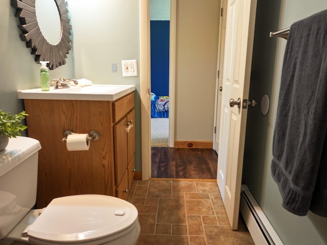 141 Cushman Rd, Winslow, ME 04901 - bathroom featuring toilet, vanity, baseboard heating, stone finish flooring, and baseboards