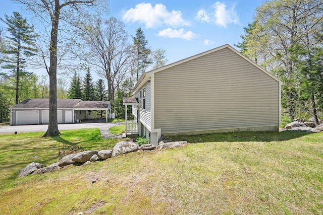 15 Northwood Ct, Wiscasset, ME 04578 - view of side of home featuring a lawn, an outbuilding, driveway, and a garage