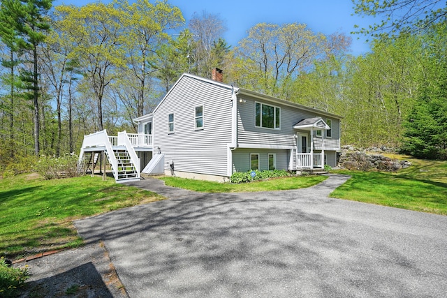 15 Northwood Ct, Wiscasset, ME 04578 - view of front of home with a chimney, stairway, a front yard, and a wooden deck