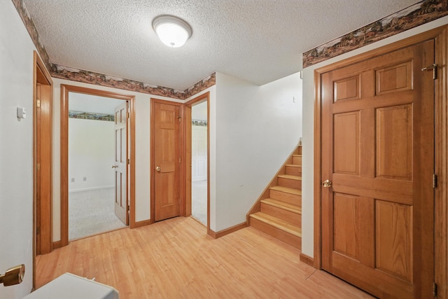 15 Northwood Ct, Wiscasset, ME 04578 - foyer featuring light wood-style flooring, a textured ceiling, stairs, and baseboards