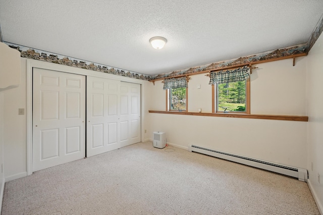 15 Northwood Ct, Wiscasset, ME 04578 - unfurnished bedroom with a baseboard radiator, carpet floors, a textured ceiling, a closet, and baseboards