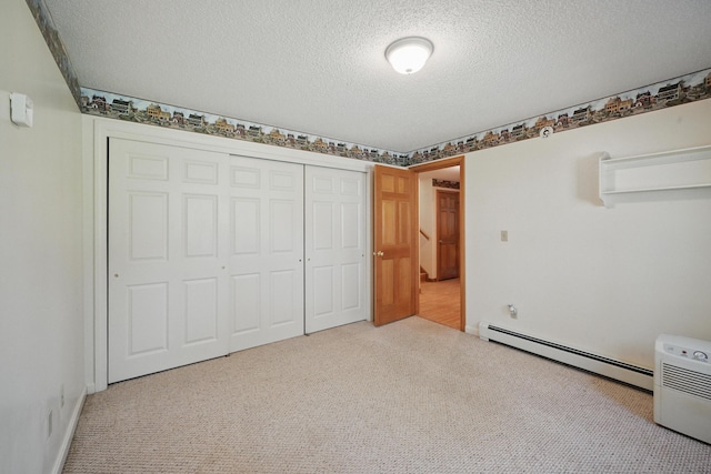 15 Northwood Ct, Wiscasset, ME 04578 - unfurnished bedroom with a baseboard radiator, carpet flooring, a textured ceiling, and a closet