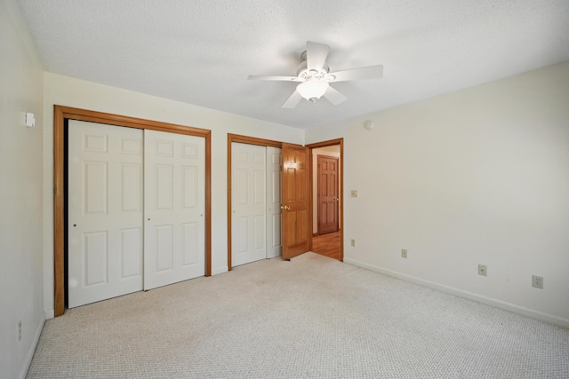15 Northwood Ct, Wiscasset, ME 04578 - unfurnished bedroom featuring two closets, light carpet, baseboards, and a ceiling fan