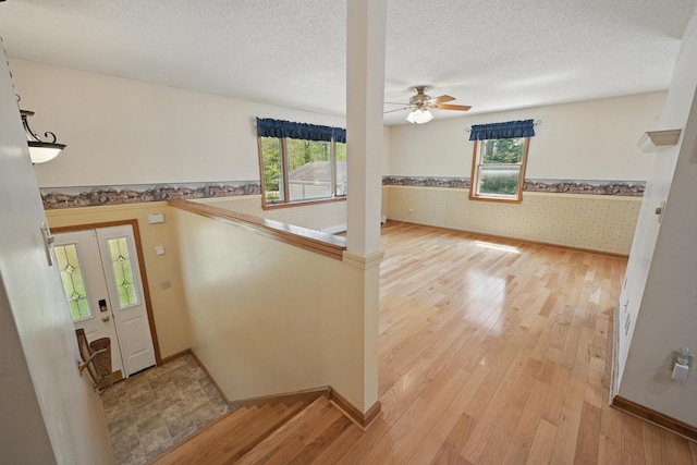 15 Northwood Ct, Wiscasset, ME 04578 - entrance foyer featuring wallpapered walls, light wood-style floors, a ceiling fan, a wainscoted wall, and baseboards