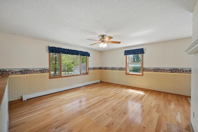 15 Northwood Ct, Wiscasset, ME 04578 - unfurnished room with wallpapered walls, wainscoting, light wood finished floors, ceiling fan, and baseboards