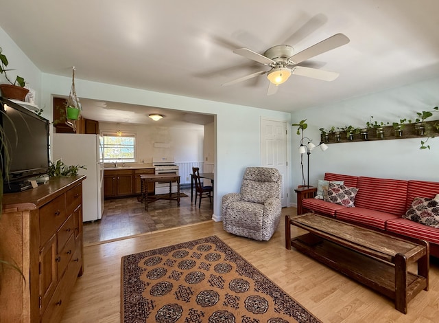 living room with light wood-type flooring and ceiling fan