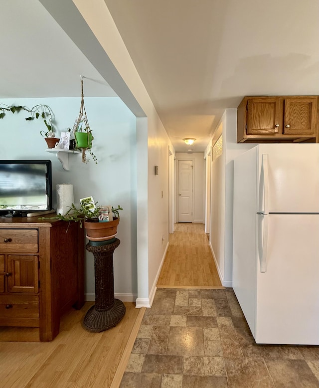 corridor with baseboards and stone finish flooring