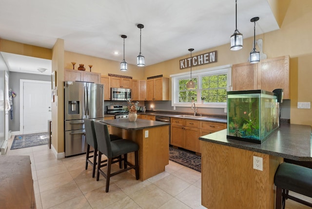 76 Asbury Ln, Acton, ME 04001 - kitchen featuring stainless steel appliances, a sink, a breakfast bar, a peninsula, and dark countertops
