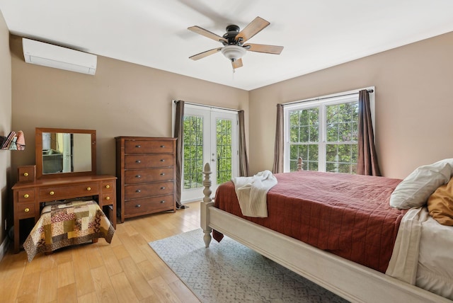 76 Asbury Ln, Acton, ME 04001 - bedroom with an AC wall unit, light wood-type flooring, access to exterior, a ceiling fan, and french doors