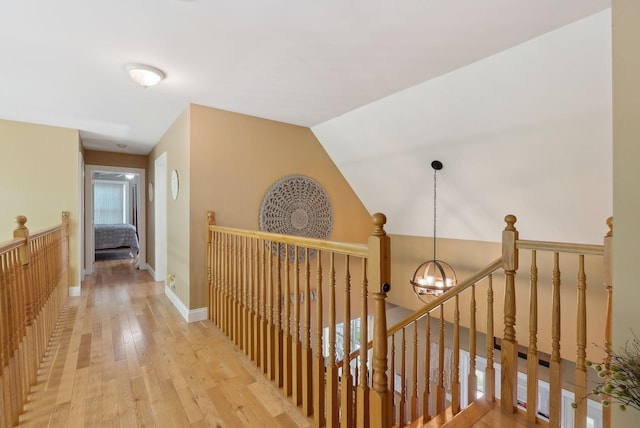 76 Asbury Ln, Acton, ME 04001 - hallway featuring an upstairs landing, a chandelier, light wood finished floors, and baseboards