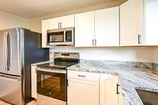 57 Mountfort St, Portland, ME 04101 - kitchen featuring appliances with stainless steel finishes, white cabinets, and light stone counters