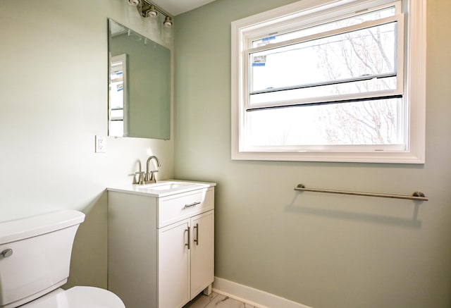 57 Mountfort St, Portland, ME 04101 - half bath with vanity, toilet, baseboards, and marble look tiles