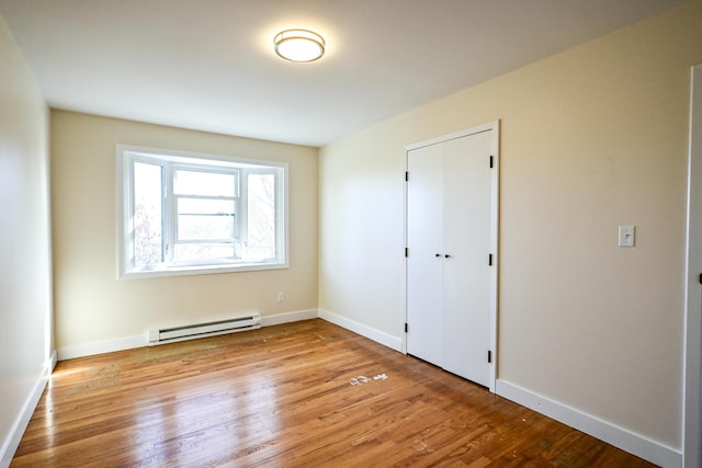 57 Mountfort St, Portland, ME 04101 - unfurnished bedroom featuring a baseboard radiator, wood finished floors, and baseboards